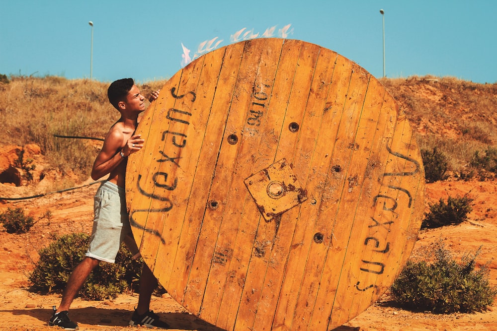 man pulling brown spool