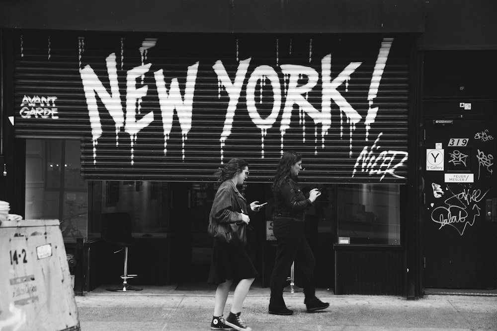 grayscale photography of two women walking