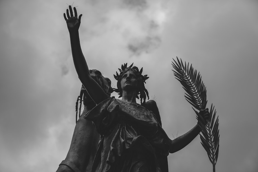 greyscale photography of woman holding palm leaf