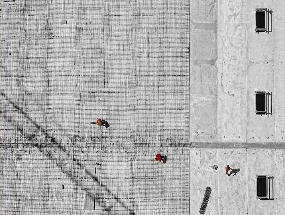 foto aerea di tre persone che camminano sul pavimento durante il giorno