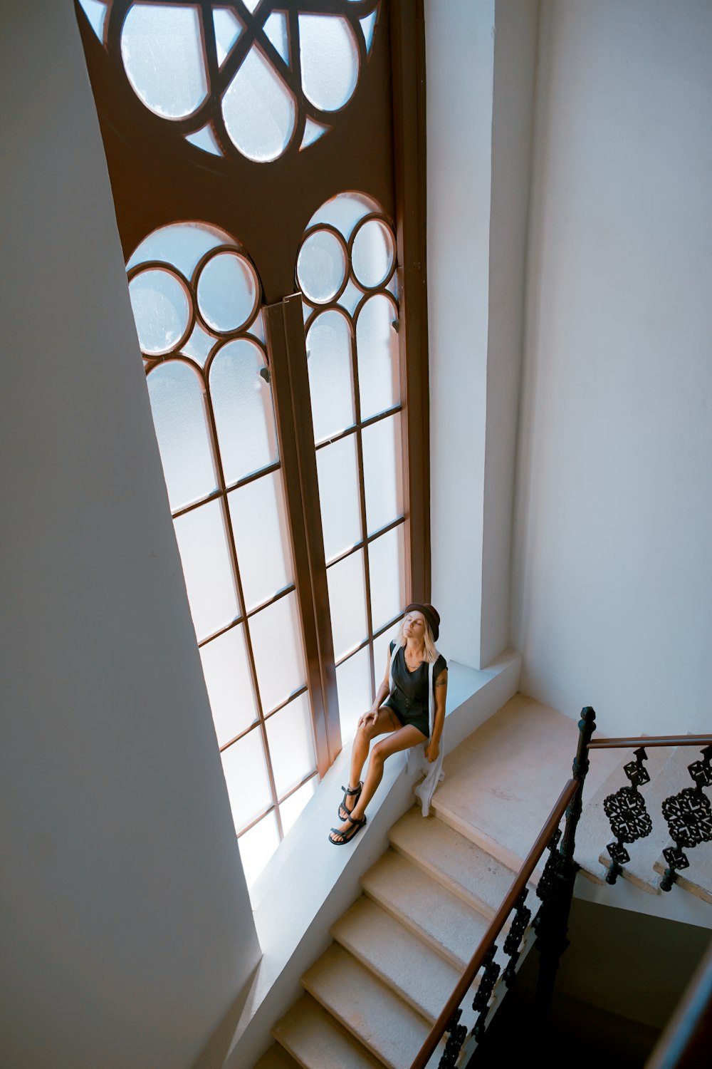 Frau sitzt am Treppenfenster