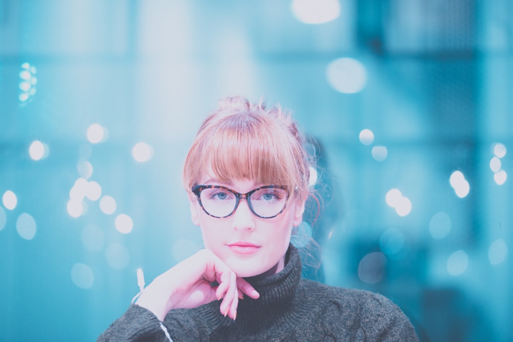 Femme portant un pull à col roulé gris posant devant la caméra