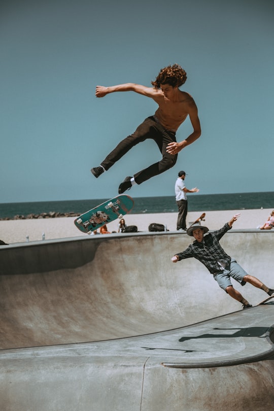 two men skateboarding on bowl ramp in Venice United States