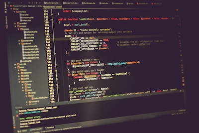 A computer screen displaying lines of code in a development environment. The code includes PHP syntax with functions, variables, and comments. The background is dark, and there are several open tabs with file names on the side.