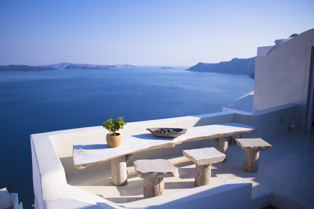 bench and dining table near body of water under calm sky