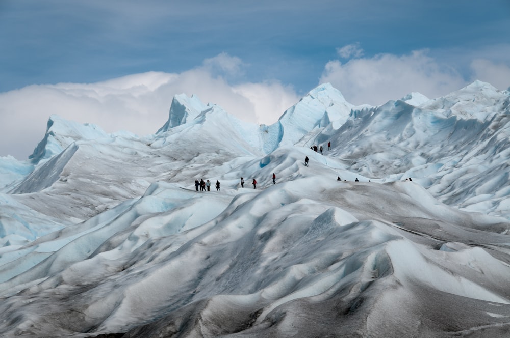 foto de personas en la cima de una montaña cubierta de nieve