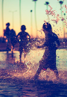 Parents and kids splashing in a private chalet swimming pool at sunset.