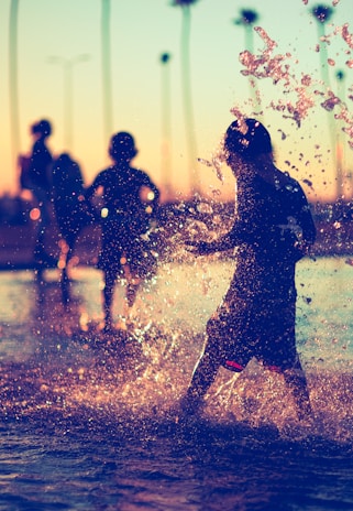 Children playing joyfully in a neighborhood park during golden hour.