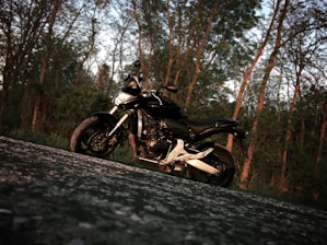 A tow truck rescuing a stranded motorcycle on a rural road at sunset.
