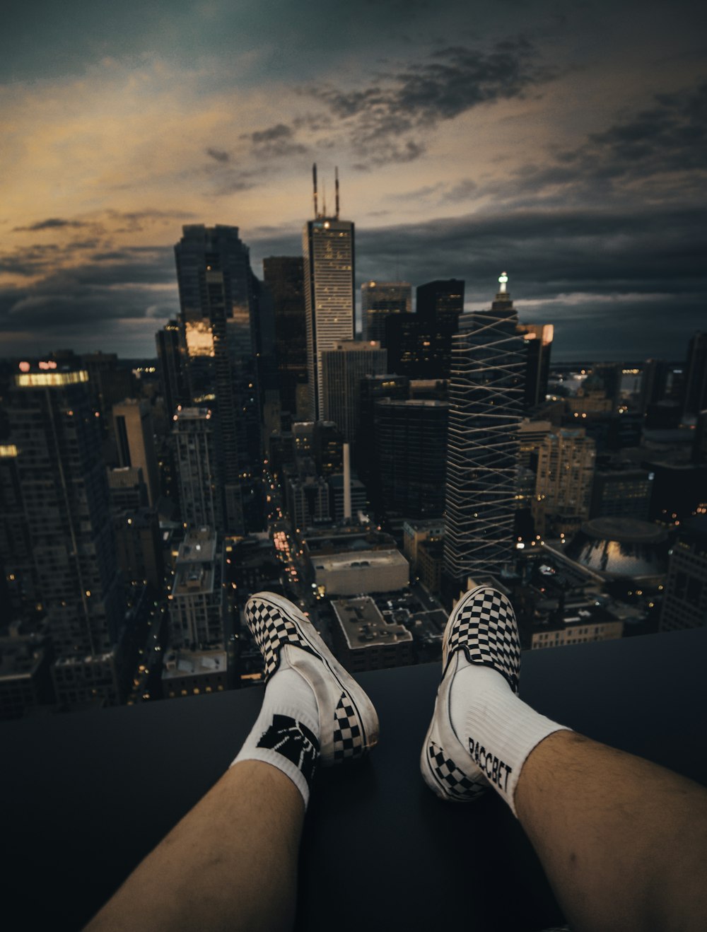 person wearing white and black adidas sneakers