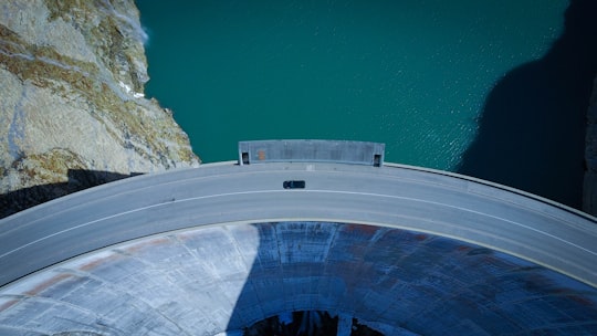 aerial view of concrete road beside body of water in Tignes France