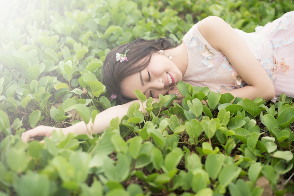 femme couchée sur l’herbe verte