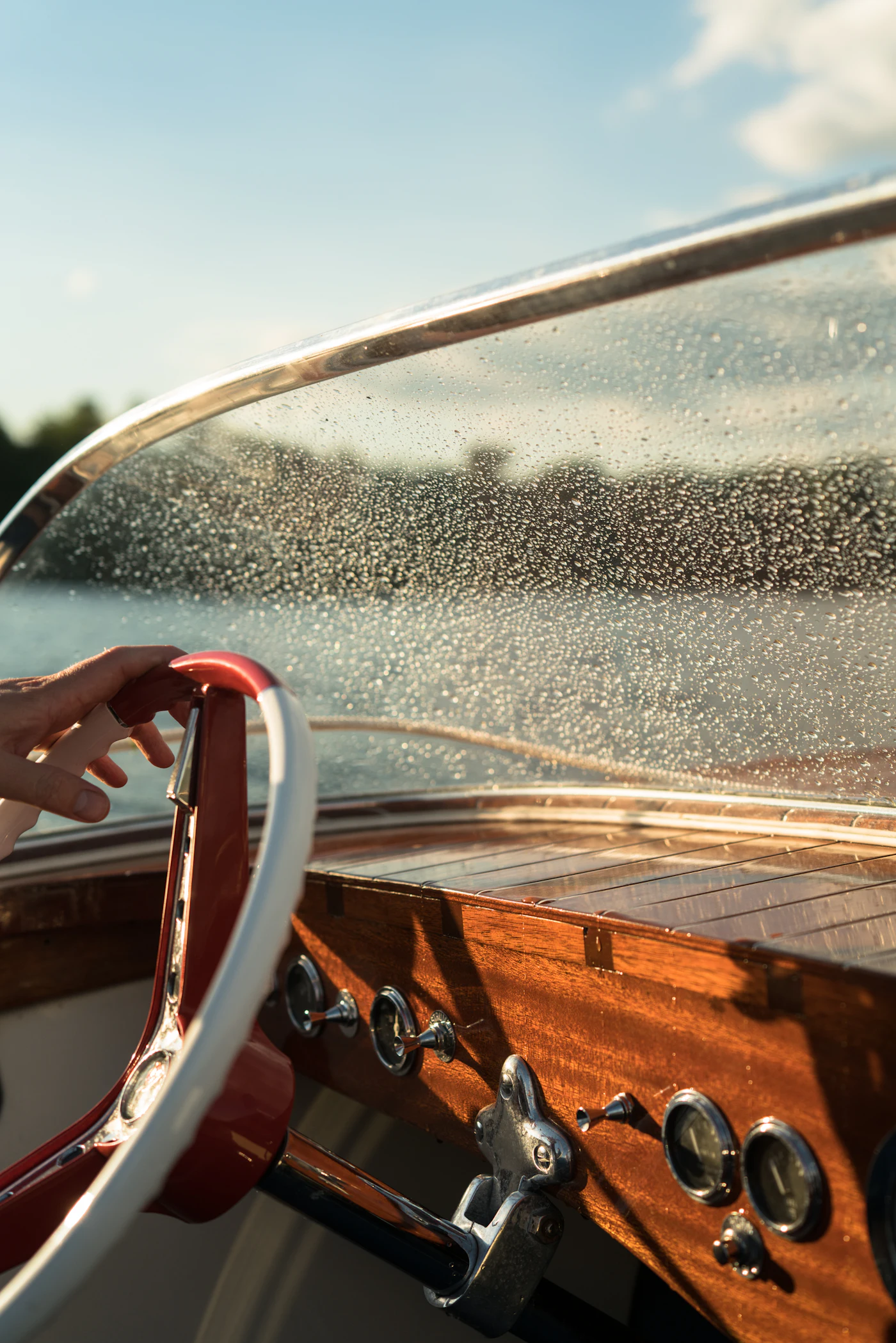 Water droplets beaded across the windshield of a classic boat