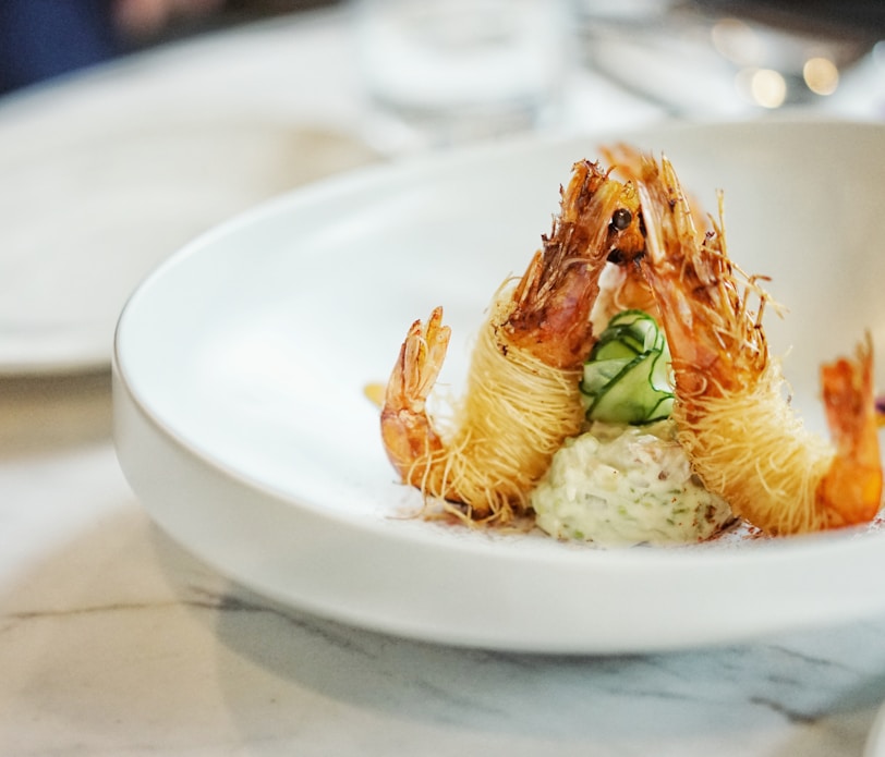 close-up photography of cooked shrimp on round white ceramic plate