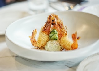 close-up photography of cooked shrimp on round white ceramic plate