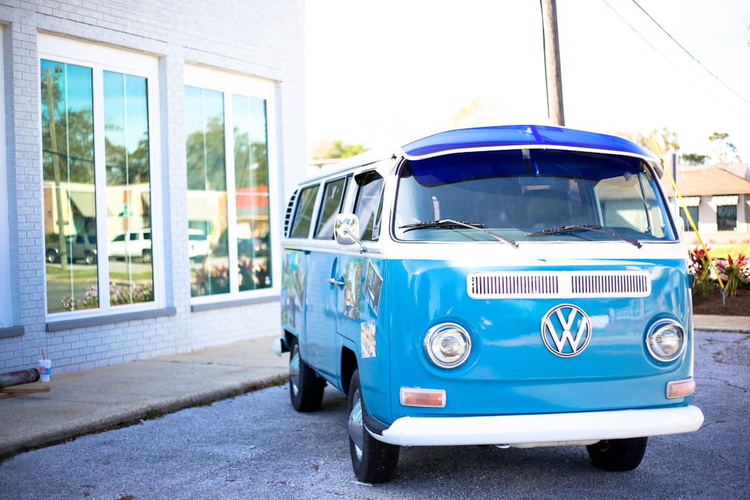 teal Volkswagen Samba in front of building