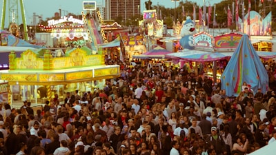 A bustling fair with attendees enjoying various attractions.