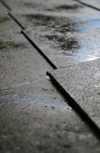 Close-up of a water droplet sliding smoothly off a treated concrete surface.