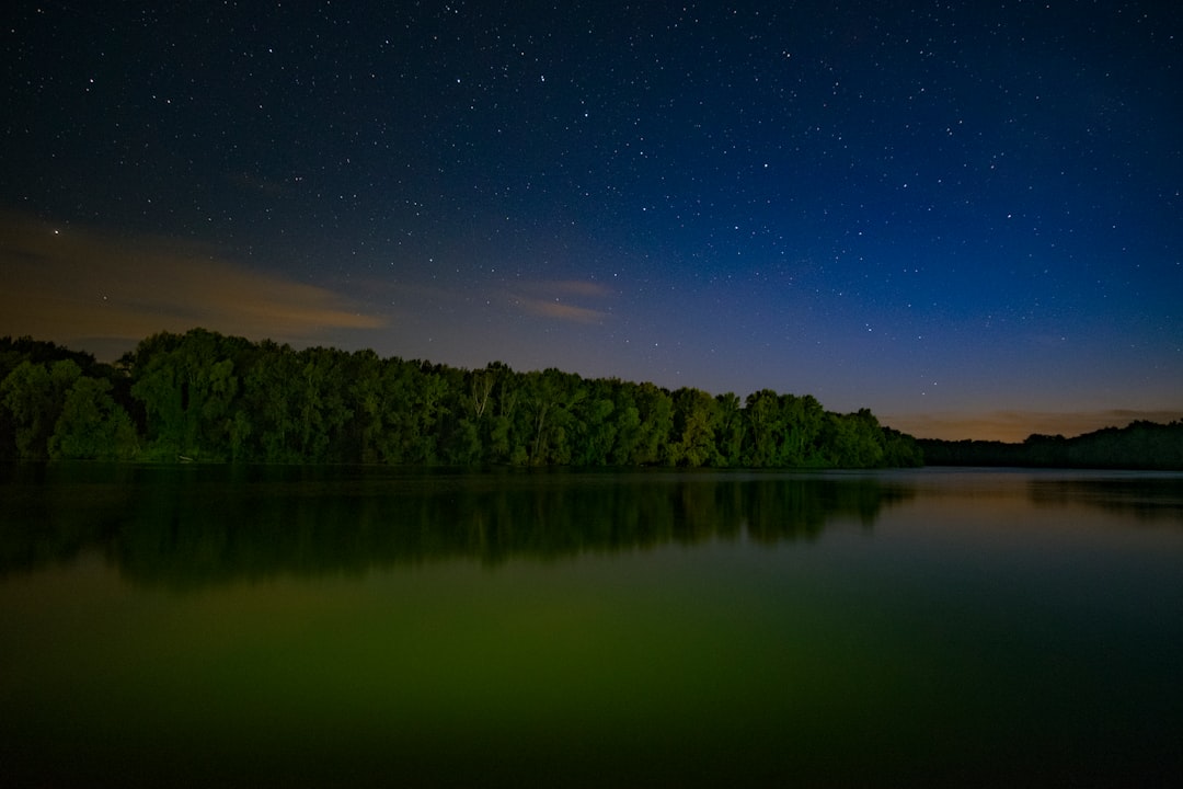 landscape photography of body of water surrounded of trees