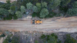 Close-up of heavy machinery in action during a forest road construction project.