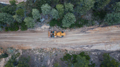 Close-up of heavy machinery in action during a forest road construction project.