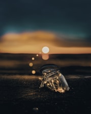 clear glass jar on sand