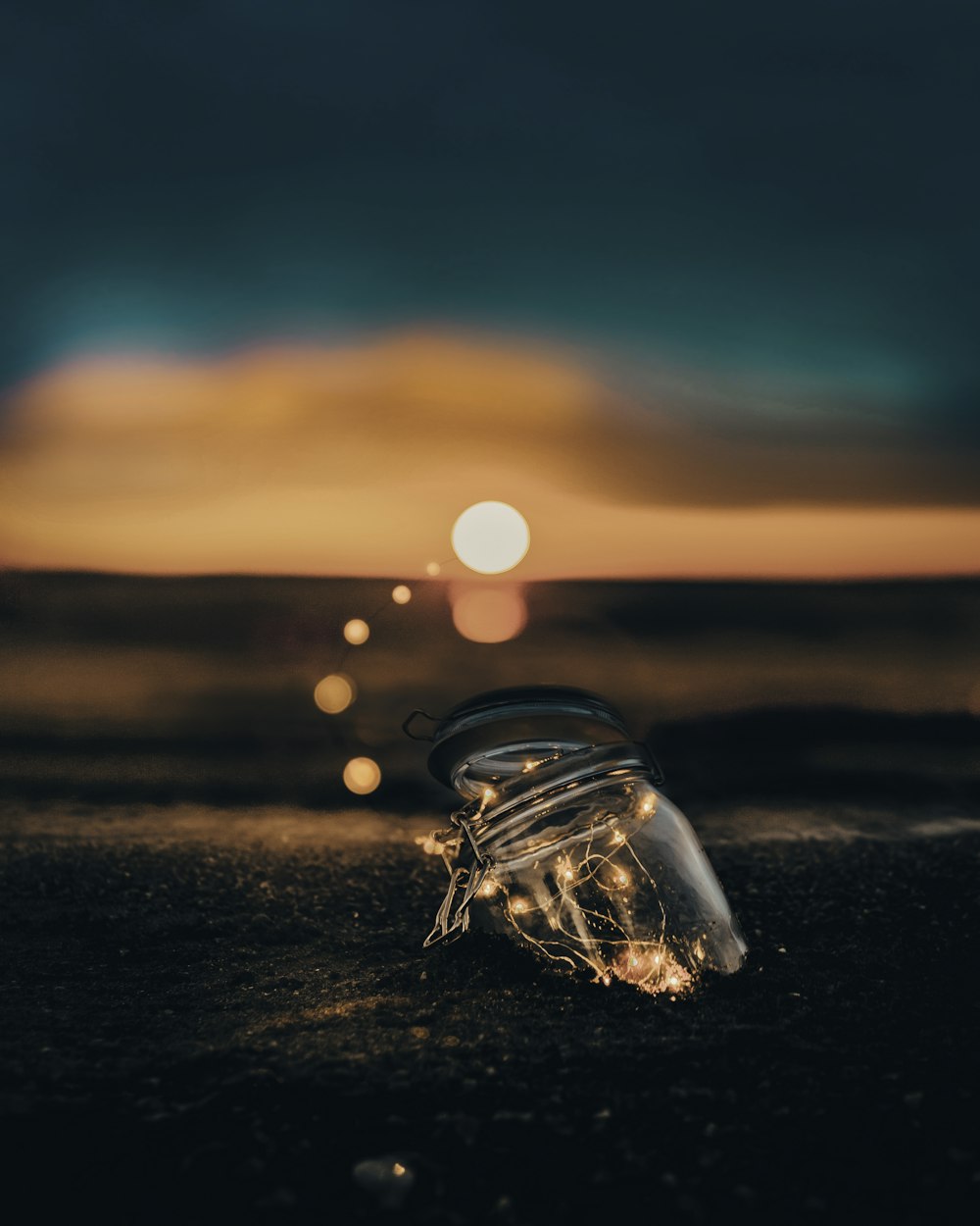 bocal en verre transparent sur sable