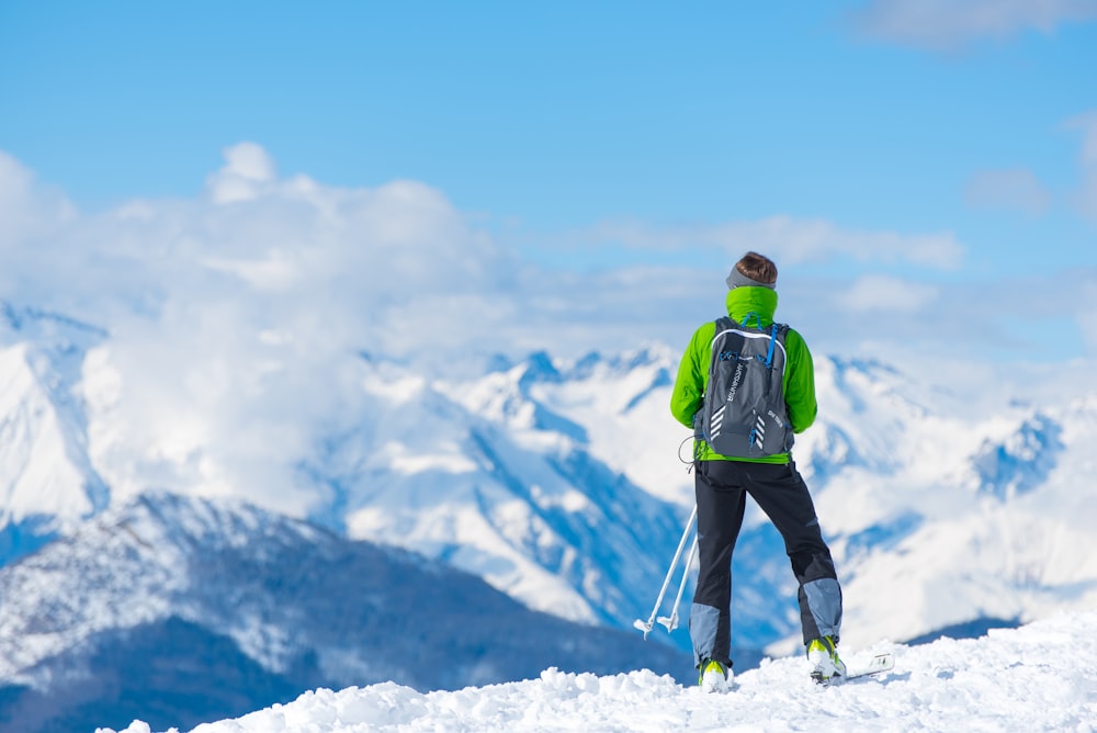 hombre de pie en la cima de la montaña nevada