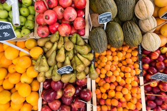 A vibrant display of fresh fruits including apples, oranges, and bananas arranged in wooden crates.