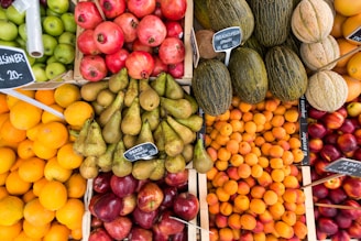 A vibrant display of assorted fresh fruits piled in wooden crates at a bustling market.