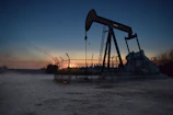 Technicians installing automation equipment on an oil well in the Orinoco Belt at sunset