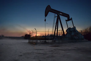 Technicians installing automation equipment on an oil well in the Orinoco Belt at sunset