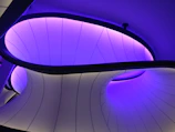 Futuristic architectural model printed in white resin, illuminated with soft purple lighting.