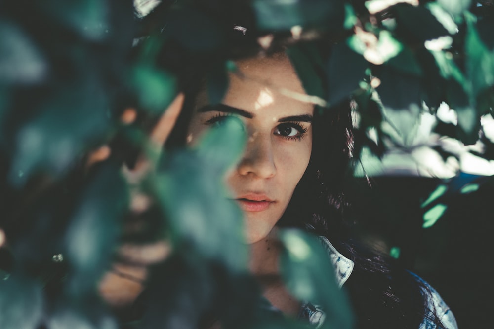 woman wearing blue denim top hiding beside grasses