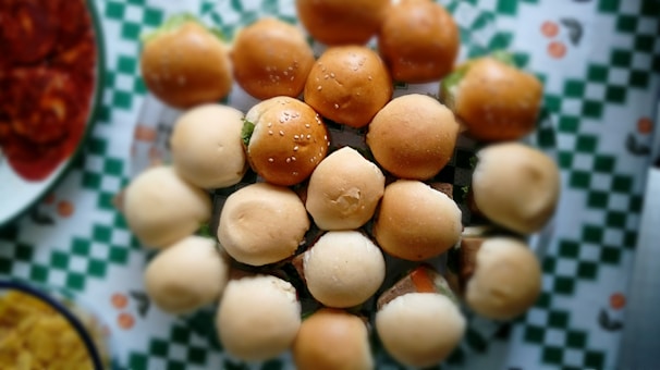 A colorful plate of assorted finger sandwiches with fresh greens and cherry tomatoes.