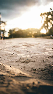 A peaceful outdoor setting with soft sand and gentle sunlight, inviting calm and presence.