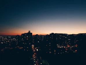 Sunset silhouette of a city skyline with gentle shadows, capturing the pulse of urban life.