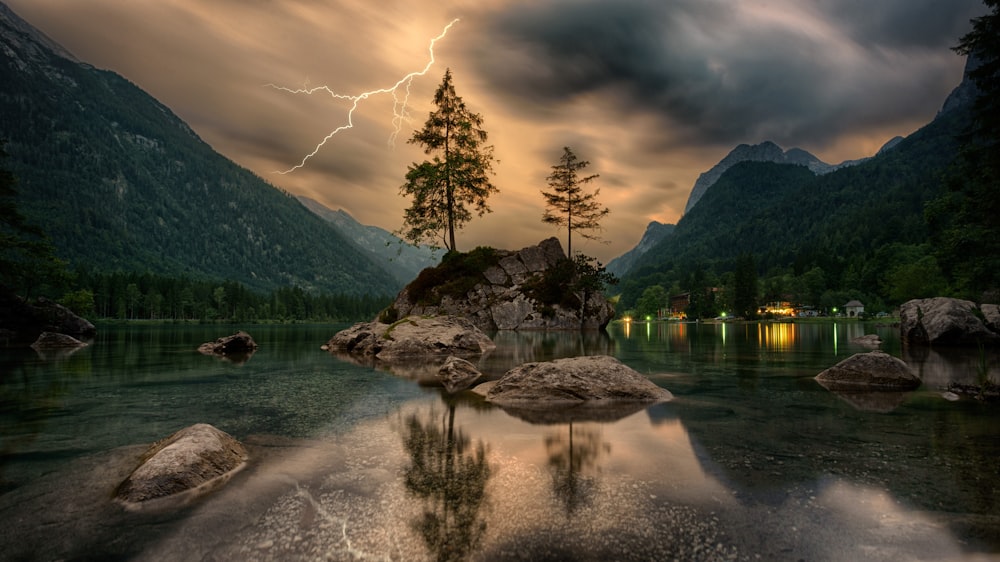 Kiefern auf Felsformationen in der Nähe von Bergen unter grauen Wolken