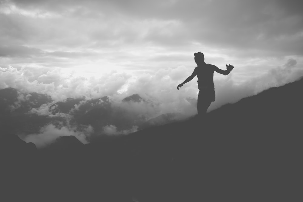 silhouette of man on mountain hill