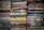 Stacks of paperback books arranged closely together, with a variety of titles and authors visible on the spines. The colors of the book covers range from muted tones to bright hues, creating a mosaic of literary works.