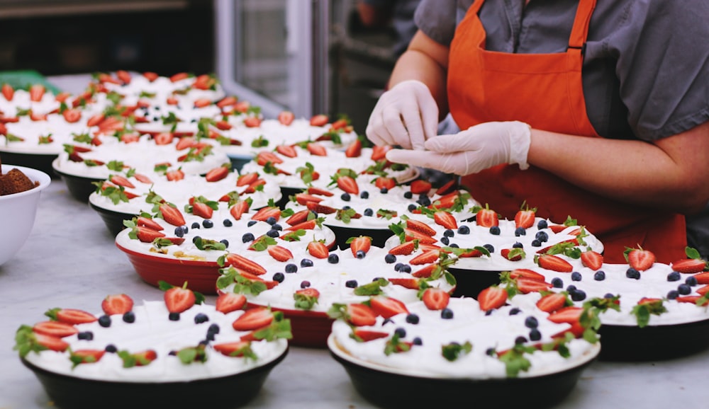 person decorating dishes on table