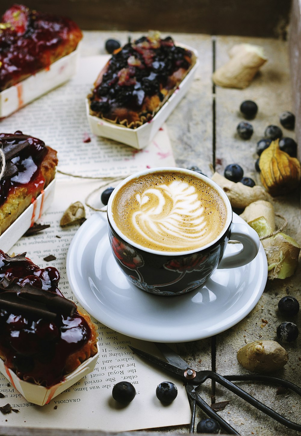 photo of brown and white teacup filled with coffee on saucer