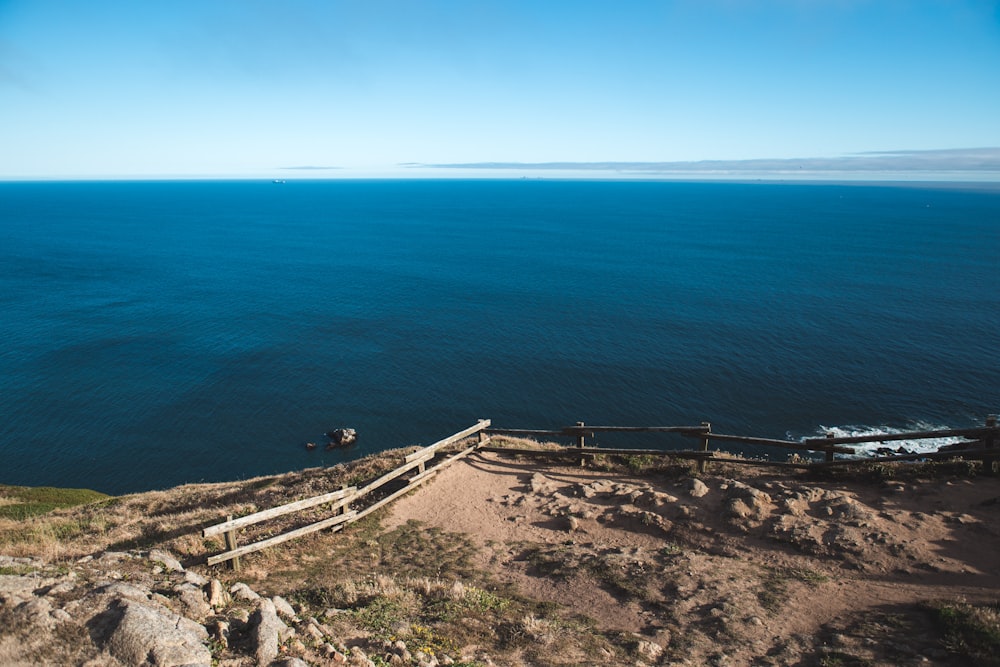 doca de madeira marrom no mar azul durante o dia