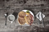 A wholesome breakfast table with pancakes and fruits.