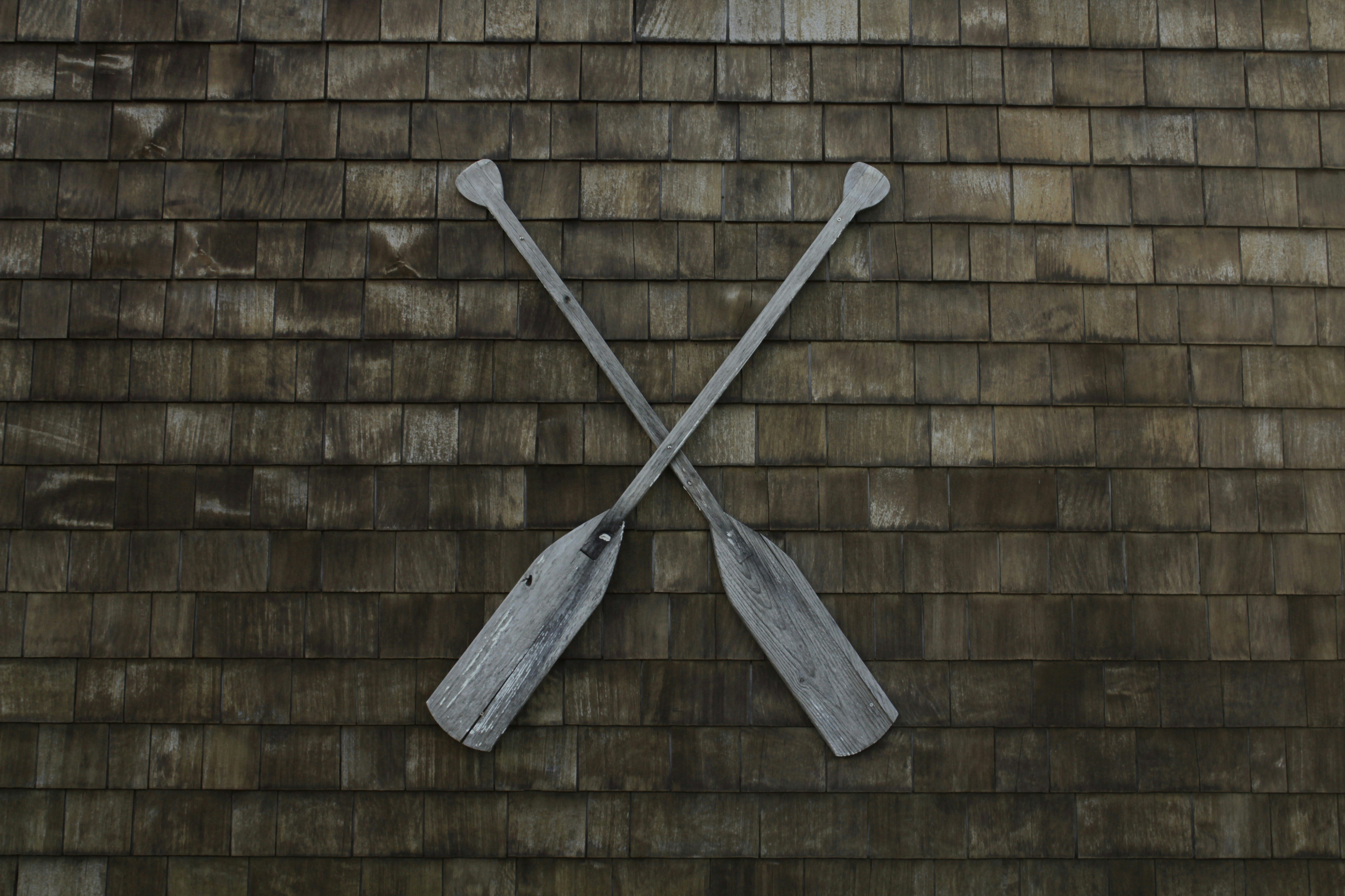 two gray wooden boat paddles hanged on wall