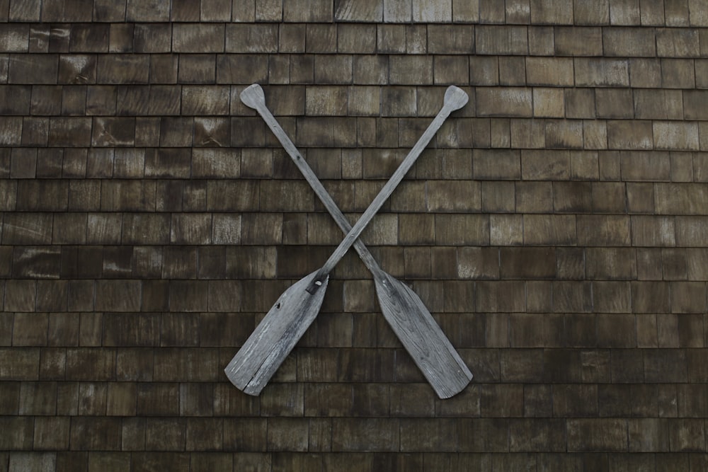 two gray wooden boat paddles hanged on wall