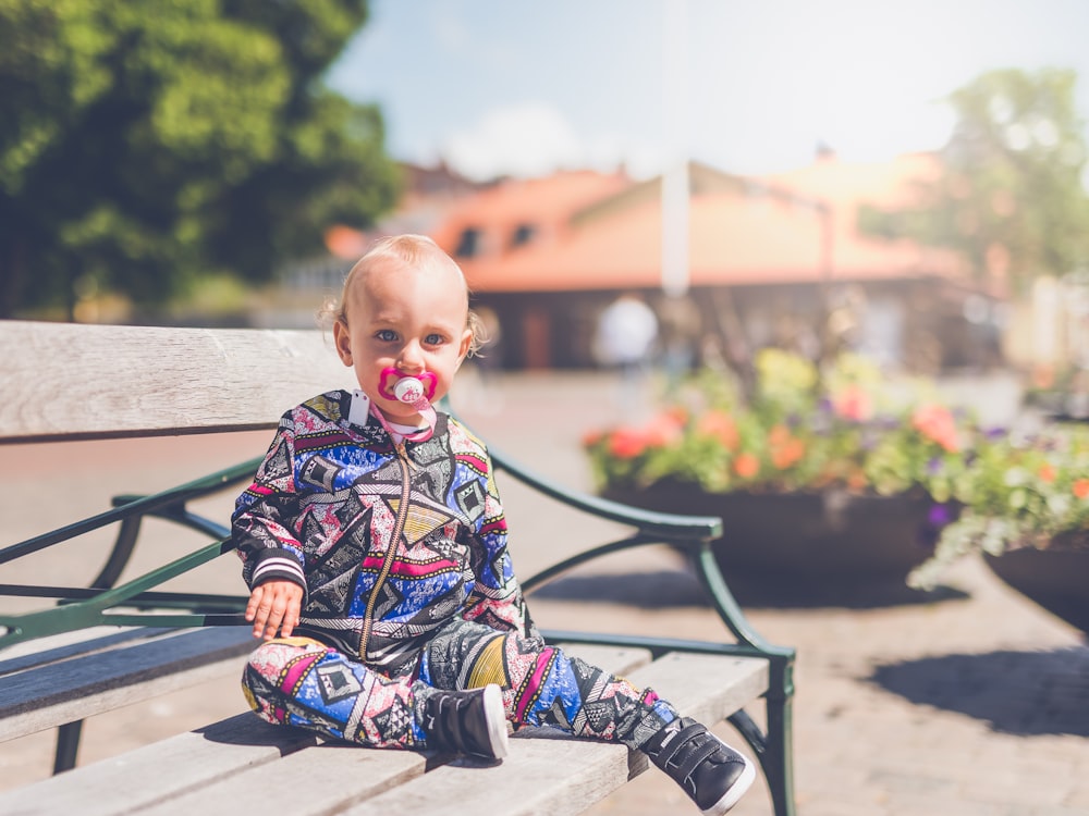 toddler sitting on wooden bench