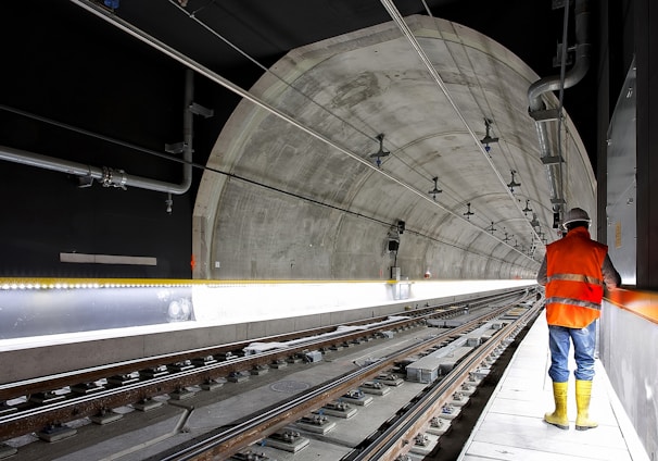 man standing beside train rail