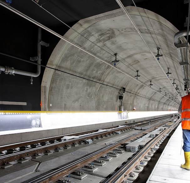 man standing beside train rail