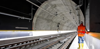 man standing beside train rail